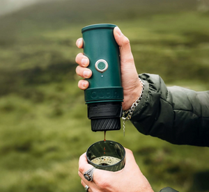 Handhållen portabel espressomaskin i canyon green med servering utomhus från portabla kaffebryggare.