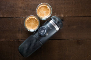 Bärbar espressomaskin med två koppar espresso på träyta, från portabla kaffebryggare och barista-utrustning